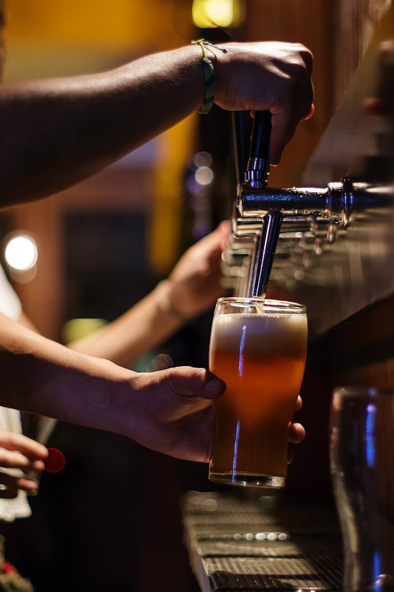 Bar staff pouring a pint during high-volume service